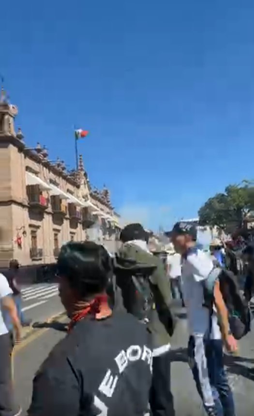 Police use tear gas to disperse protesters at the Government Palace; some of the participants try to pull down the metal barriers.